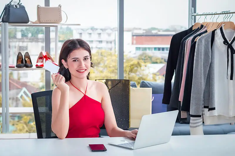 jovem mulher, moça sorridente, com notebook (laptop) vendendo online. E-commerce, loja virtual e negocio online. Dicas para presença digital de pequenos e medios negocios. JR Mídias Sites.