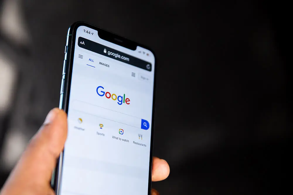 1º local em que seu negócio precisa estar para uma boa presença digital - Local de pesquisa - Mão segurando Smartphone com site Google aberto